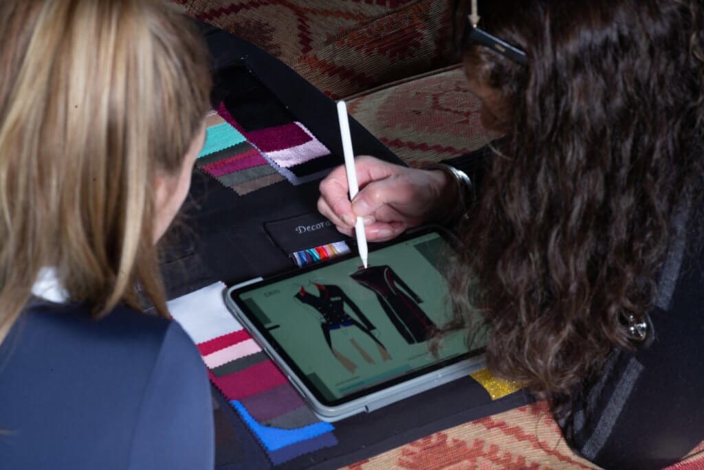 Two people using a tablet with a stylus on a colorful surface